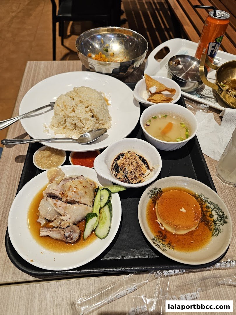 A tray of delicious food including chicken rice, soup, and dessert.