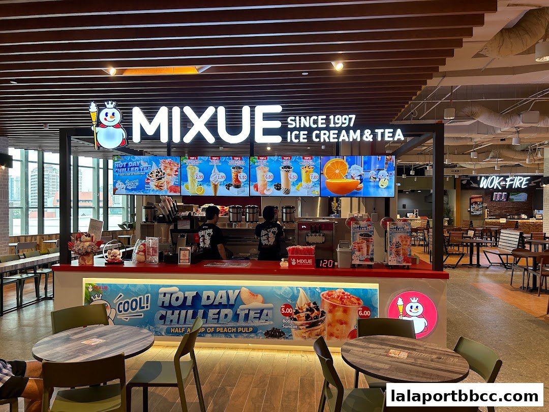 A Mixue Ice Cream & Tea shop counter with colorful product displays and seating area.