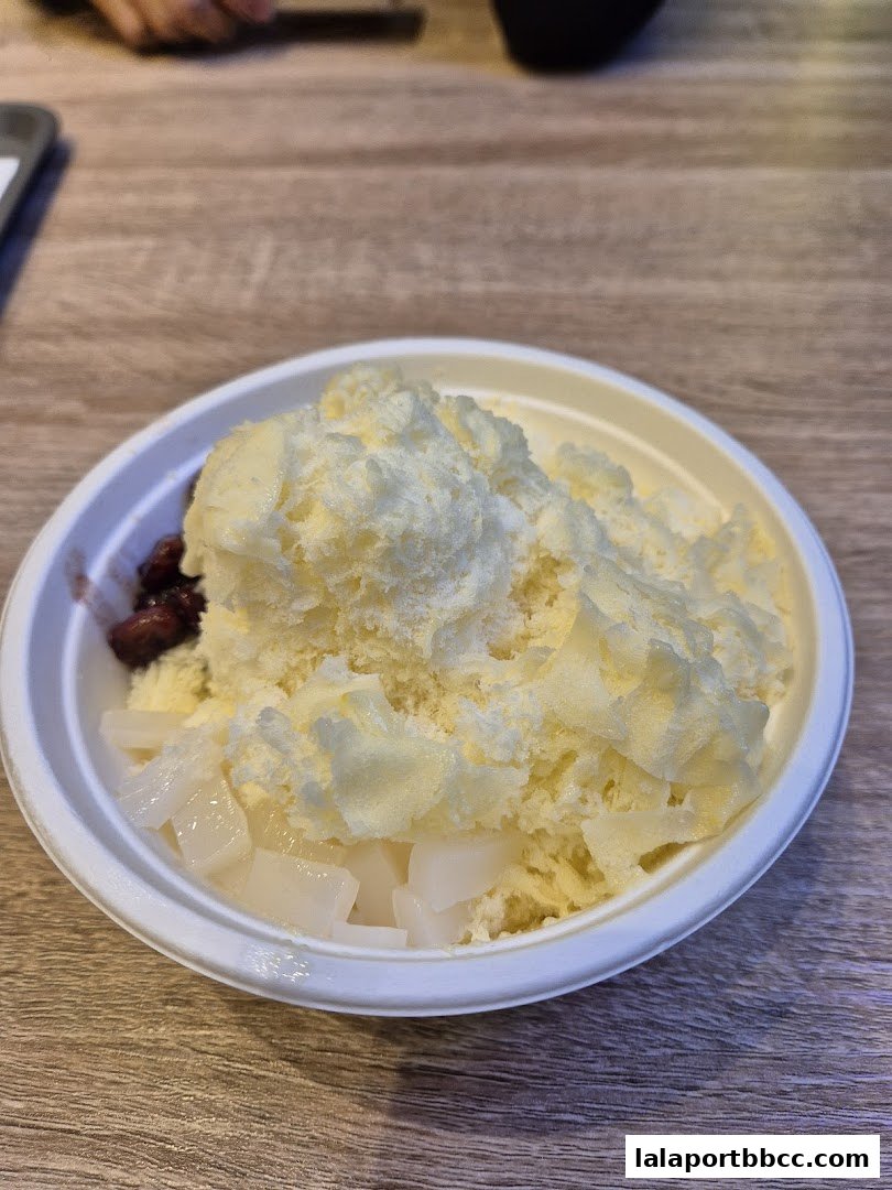 A close-up of a refreshing shaved ice dessert with red beans and coconut jelly.