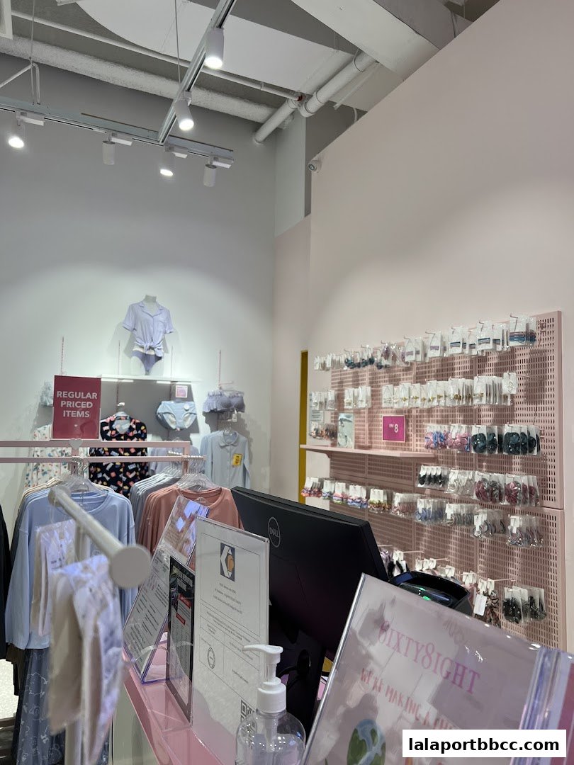 Interior view of a clothing store with apparel and accessories displayed.