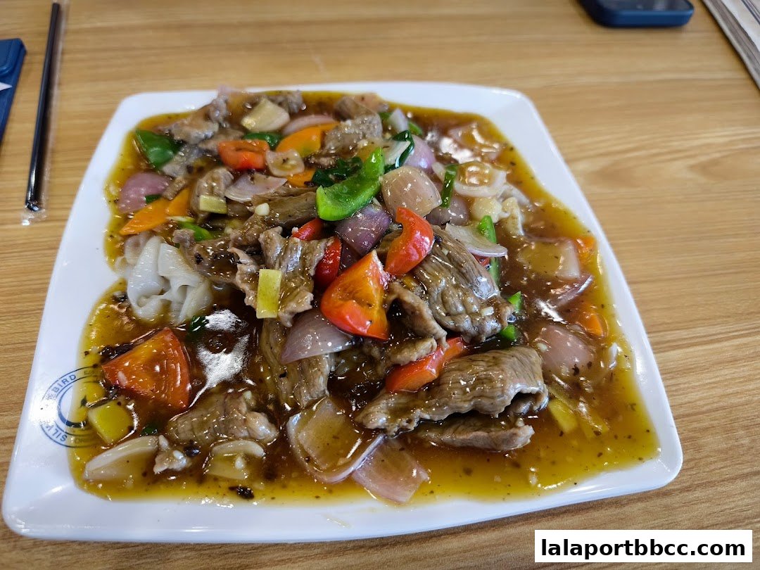A plate of stir-fried beef with vegetables in a savory sauce.
