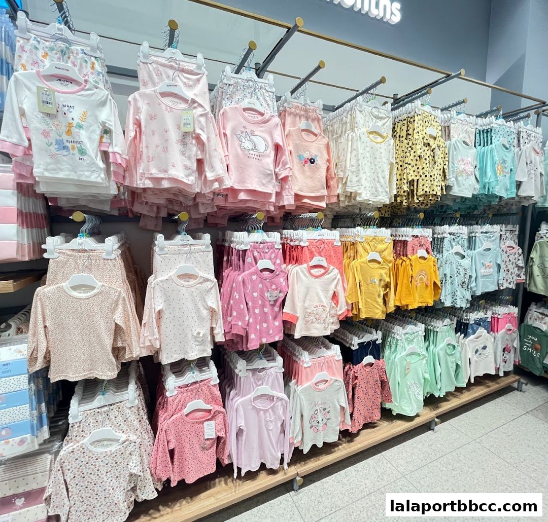 A well-organized display of baby and toddler clothing, featuring colorful pajamas and outfits.