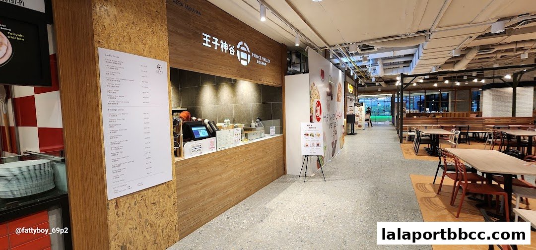A food court stall with a menu and seating area in a modern shopping mall.