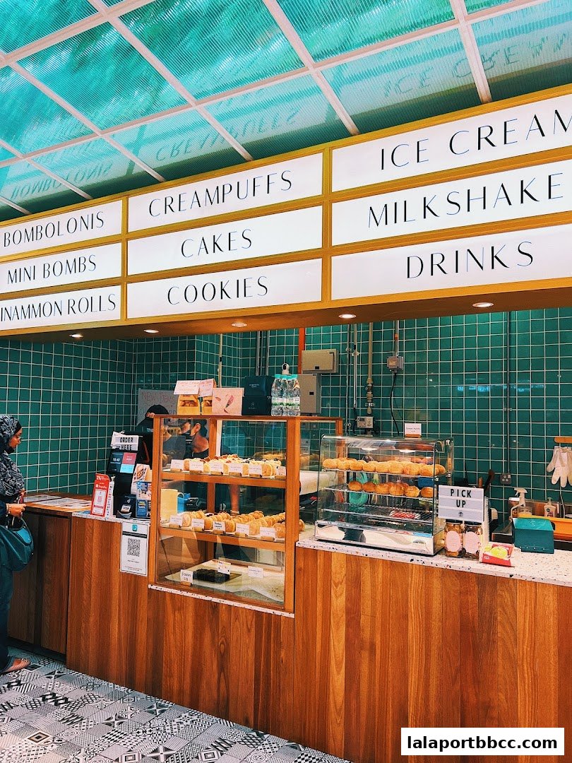 A bakery counter with a menu board displaying various sweet treats and drinks.
