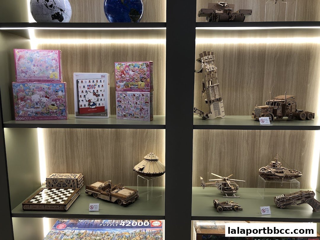 Shelves display various puzzles and intricate wooden model kits, including vehicles and tanks.
