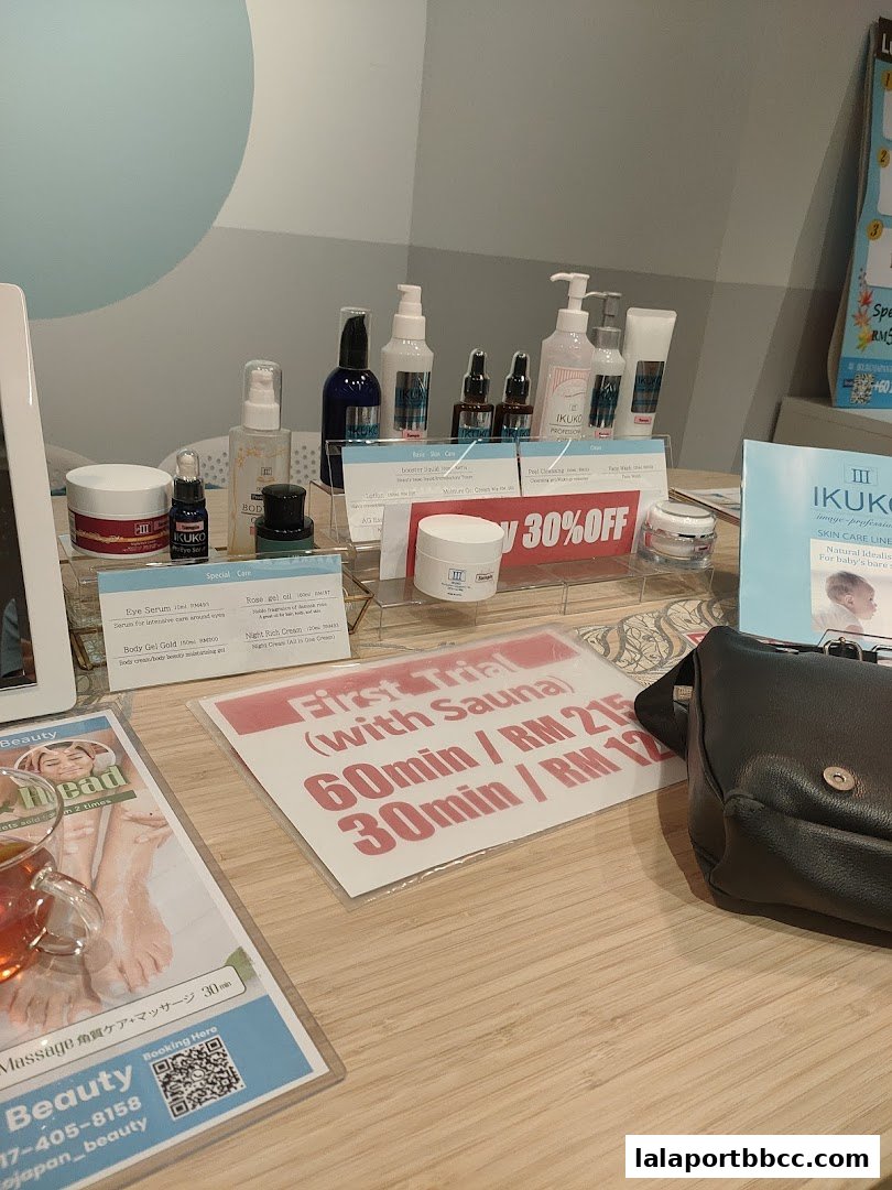 A display of IKUKO JAPAN BEAUTY skincare products and a promotional sign for a first trial with sauna.