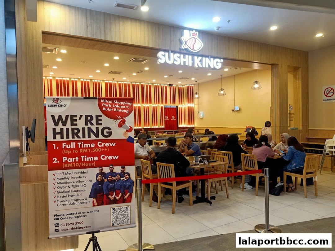 Sushi King restaurant entrance with a 'We're Hiring' banner and customers dining inside.