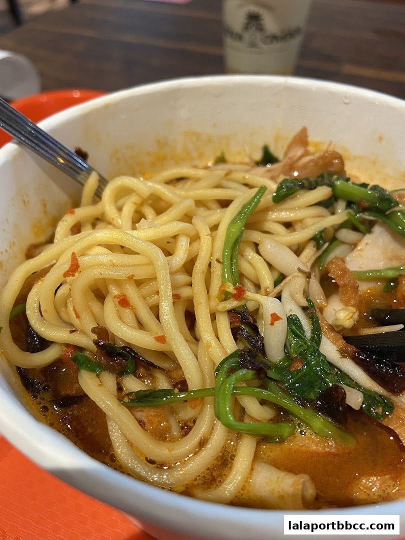 A close-up shot of a delicious bowl of noodles with broth and vegetables.