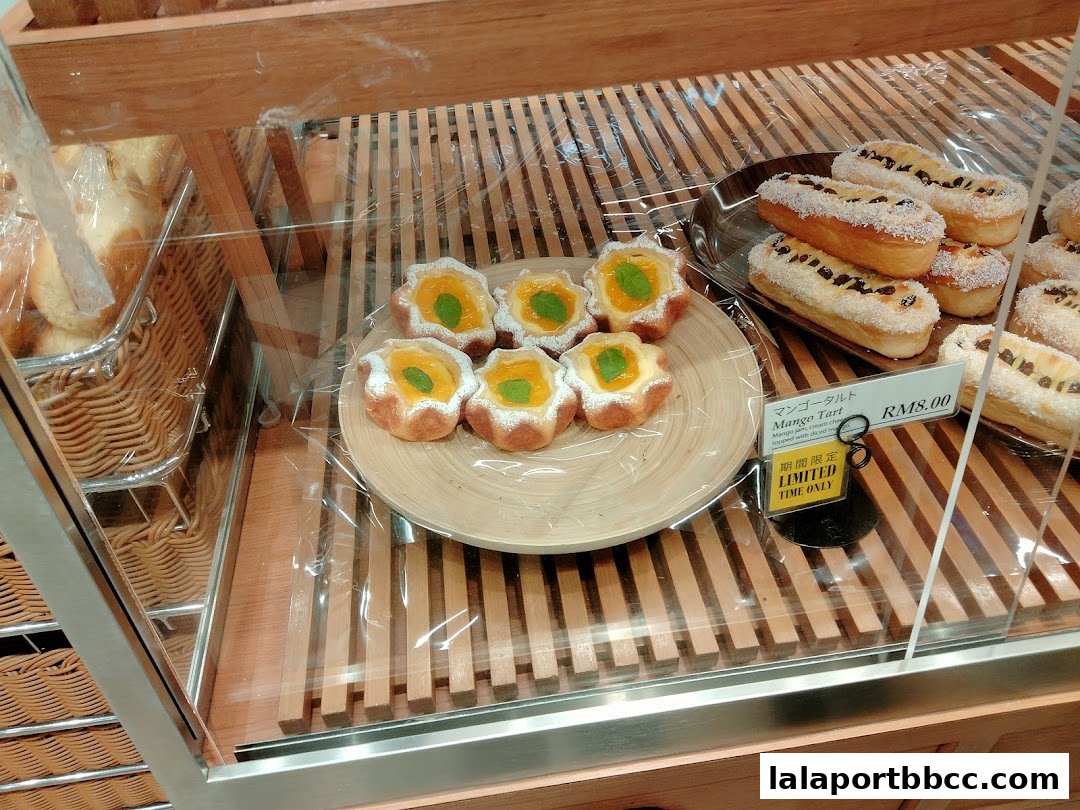 A display of freshly baked tarts and pastries in a bakery showcase.