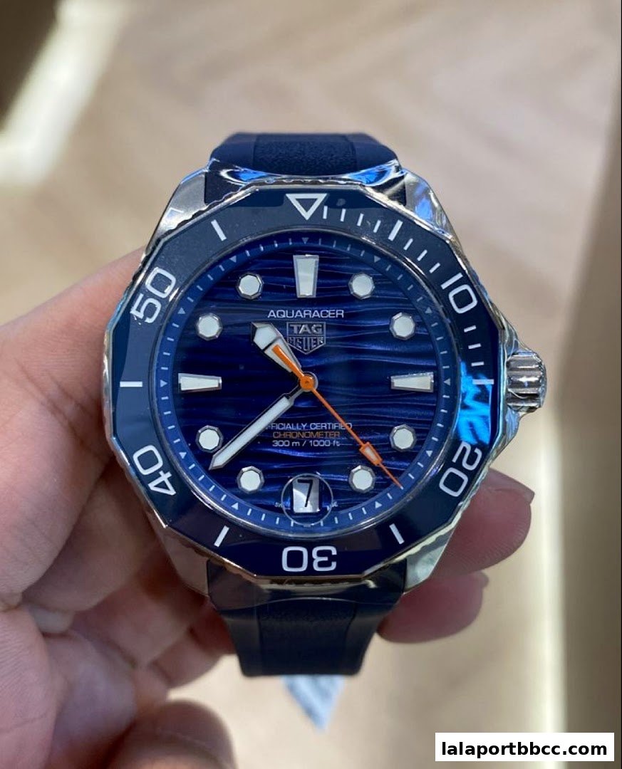 A close-up shot of a blue TAG Heuer Aquaracer watch with a rubber strap.