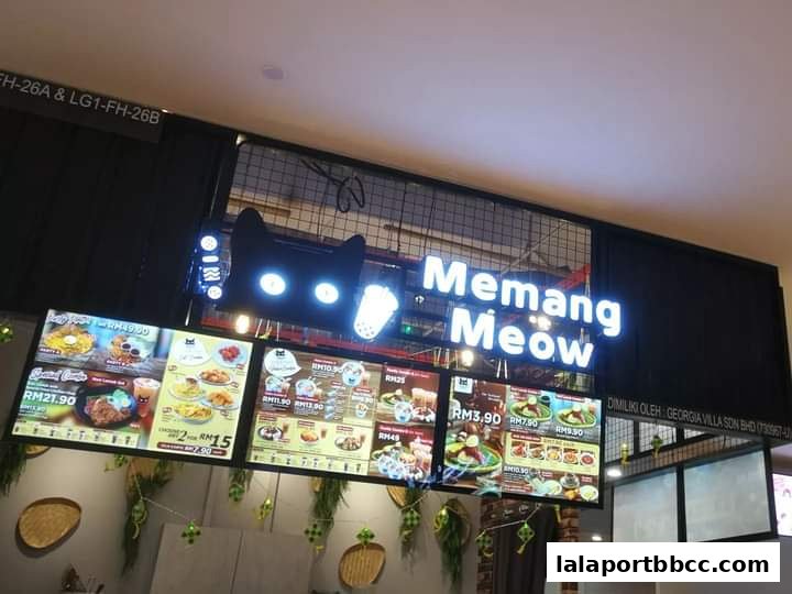 A brightly lit menu board displaying various food items and prices for Memang Meow.
