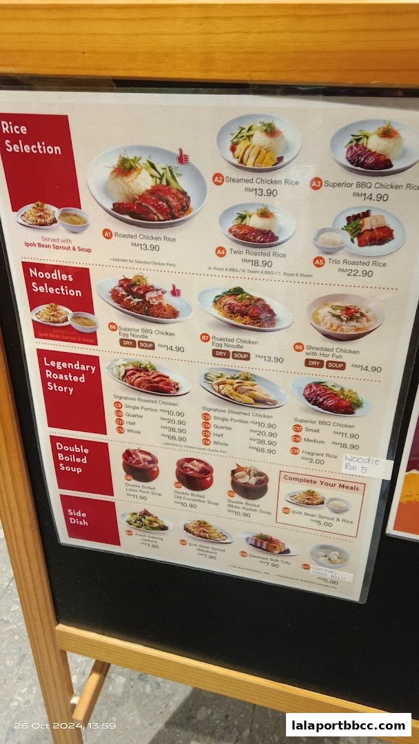 A menu board displaying various chicken rice and noodle dishes with prices.