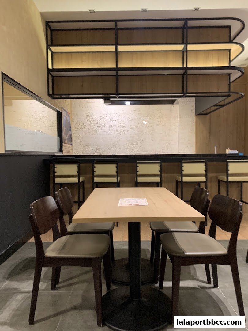 Interior view of a steakhouse with tables, chairs, and shelves.