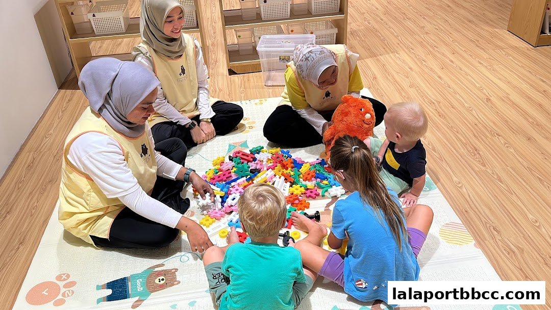 Children and caregivers engage in a colorful building block activity on a play mat.