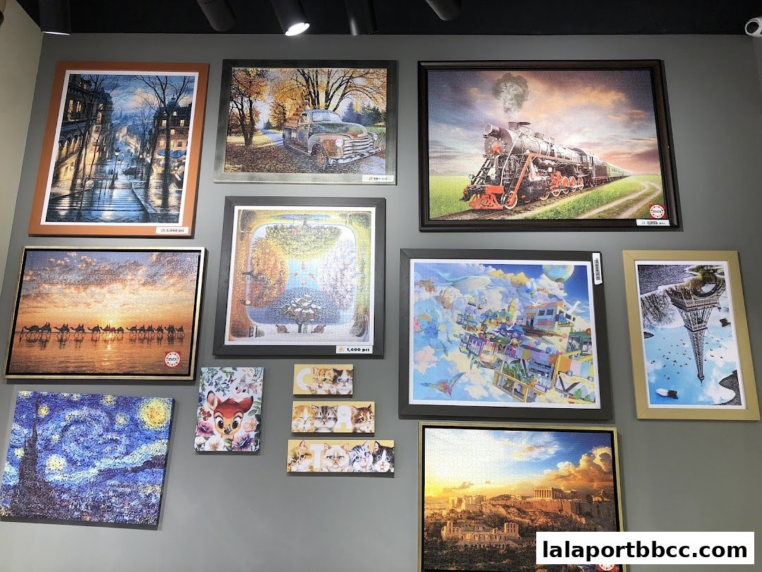 A wall displaying various framed jigsaw puzzles with diverse themes and artwork.