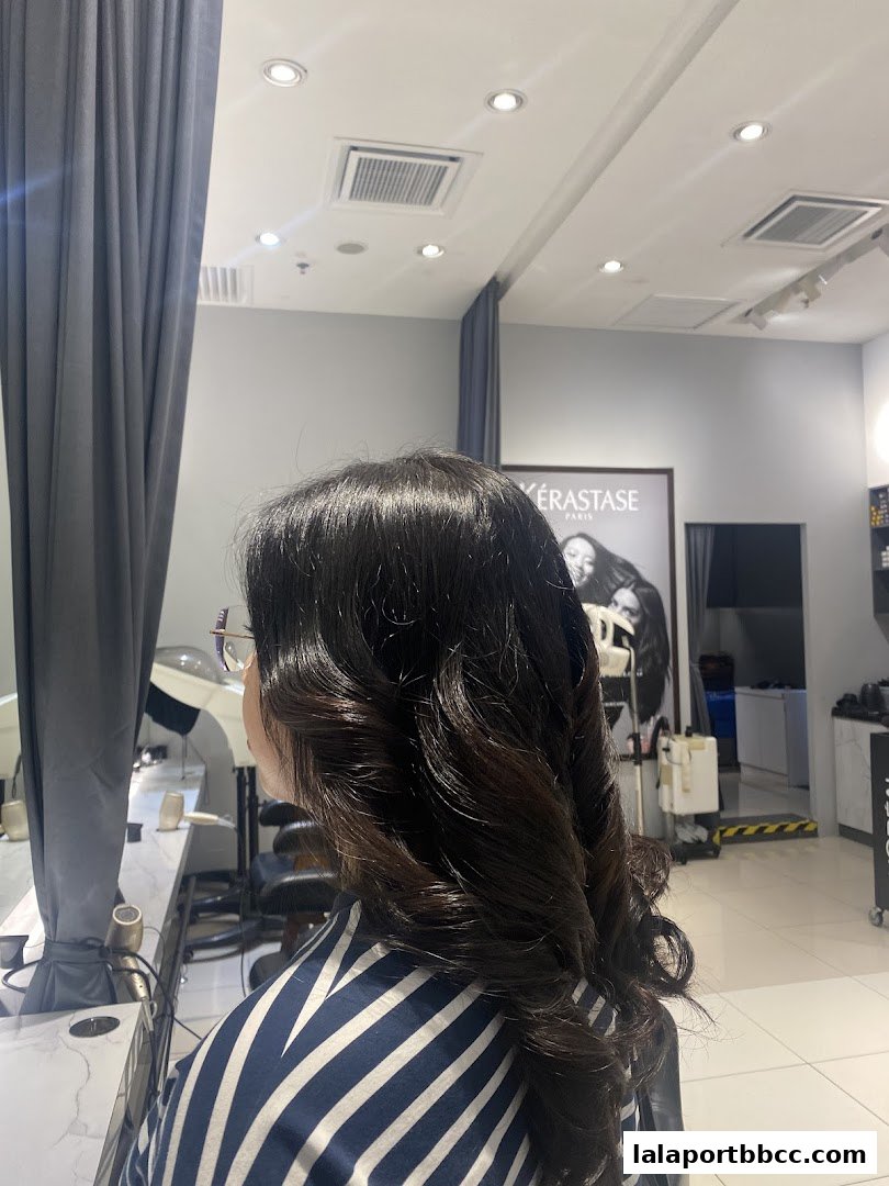 A woman with beautifully styled dark hair in a salon setting.