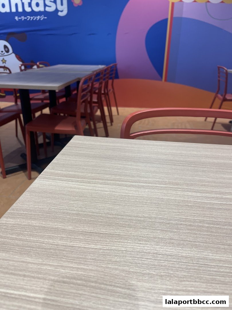 Interior shot of a dining area with tables and chairs, featuring a colorful mural.