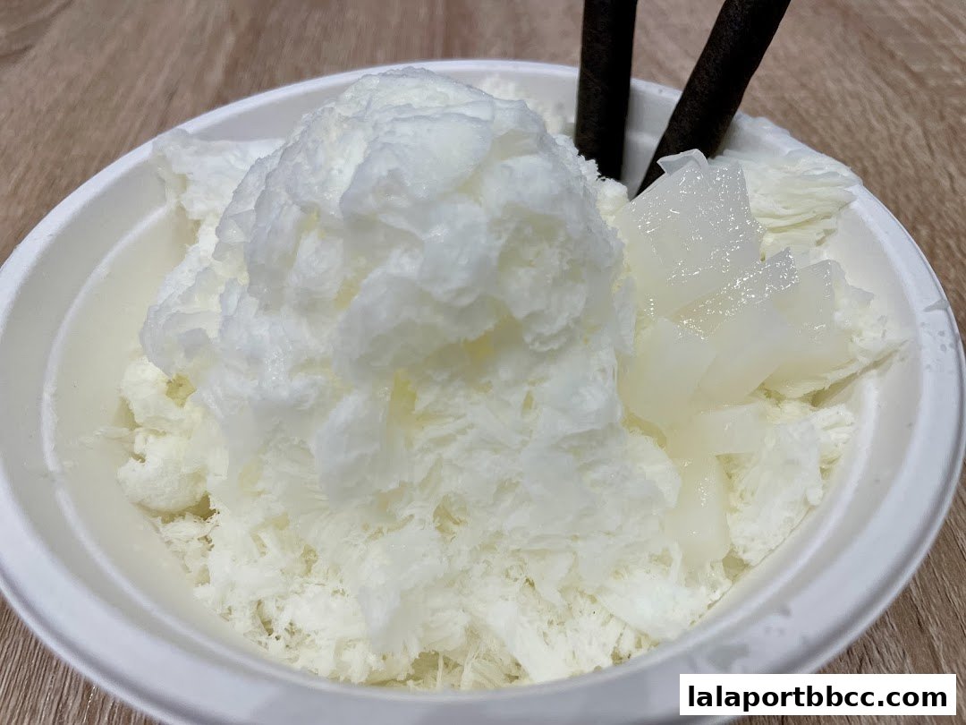 A refreshing bowl of shaved ice dessert with chocolate sticks and jelly.