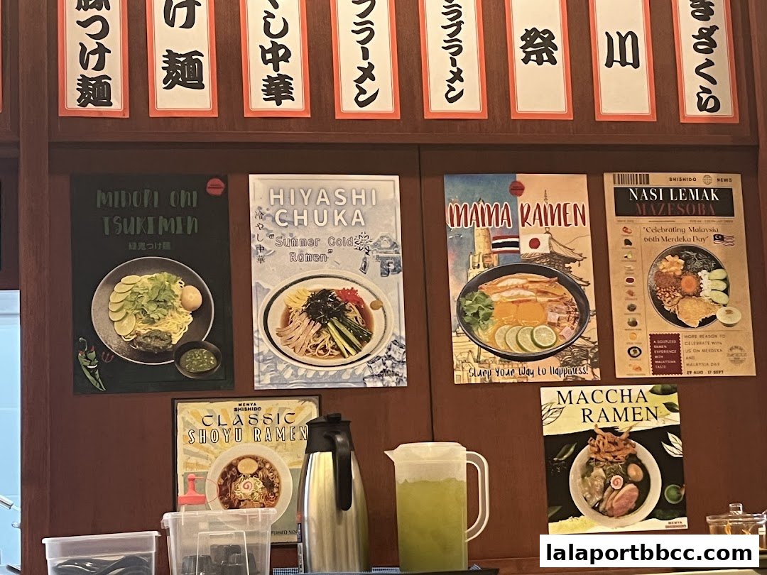 A wall display featuring various ramen dishes and Japanese text.