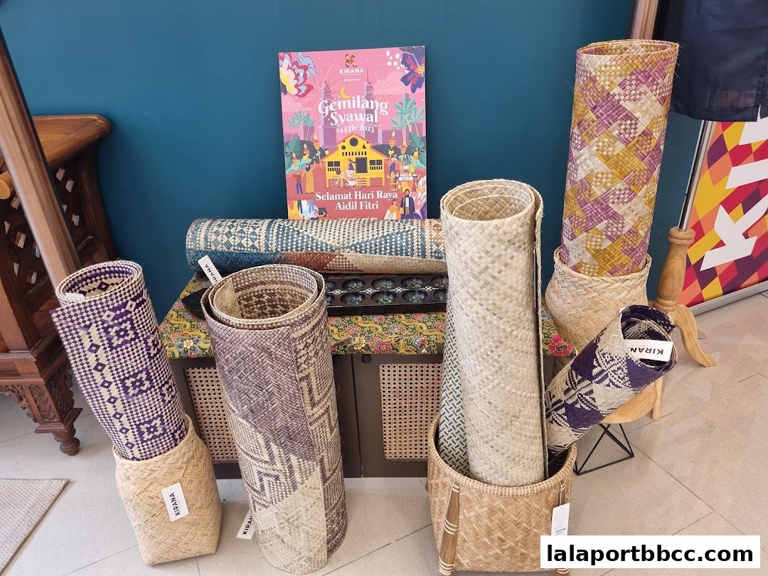 Woven mats and baskets displayed with a festive Hari Raya greeting card.