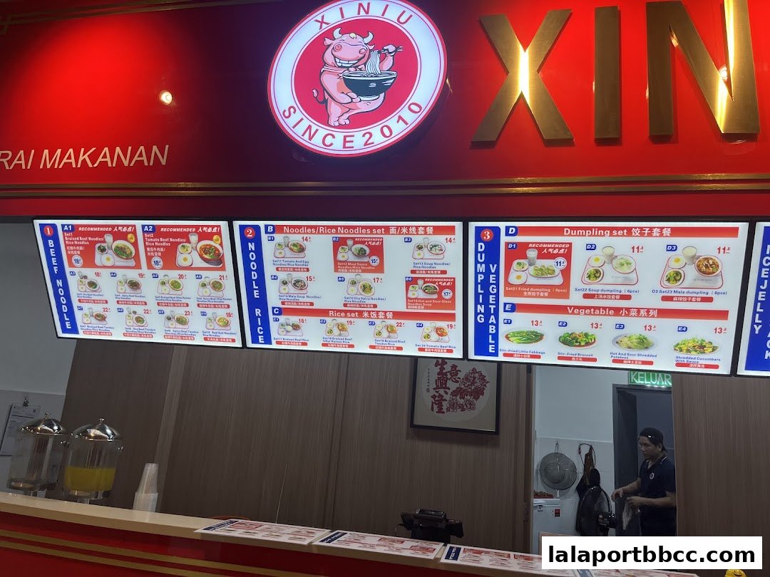 A food court menu displaying various noodle, dumpling, and vegetable sets with prices.