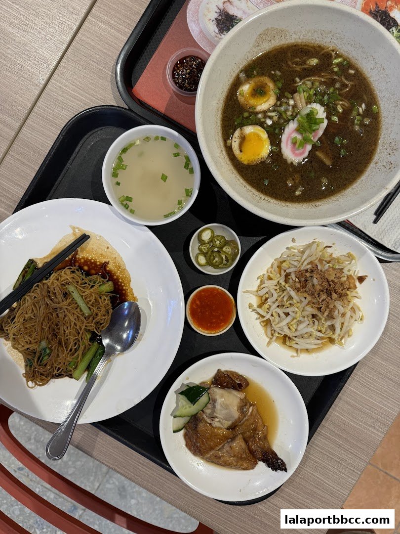 A tray of delicious food including chicken rice, noodles, soup, and bean sprouts.