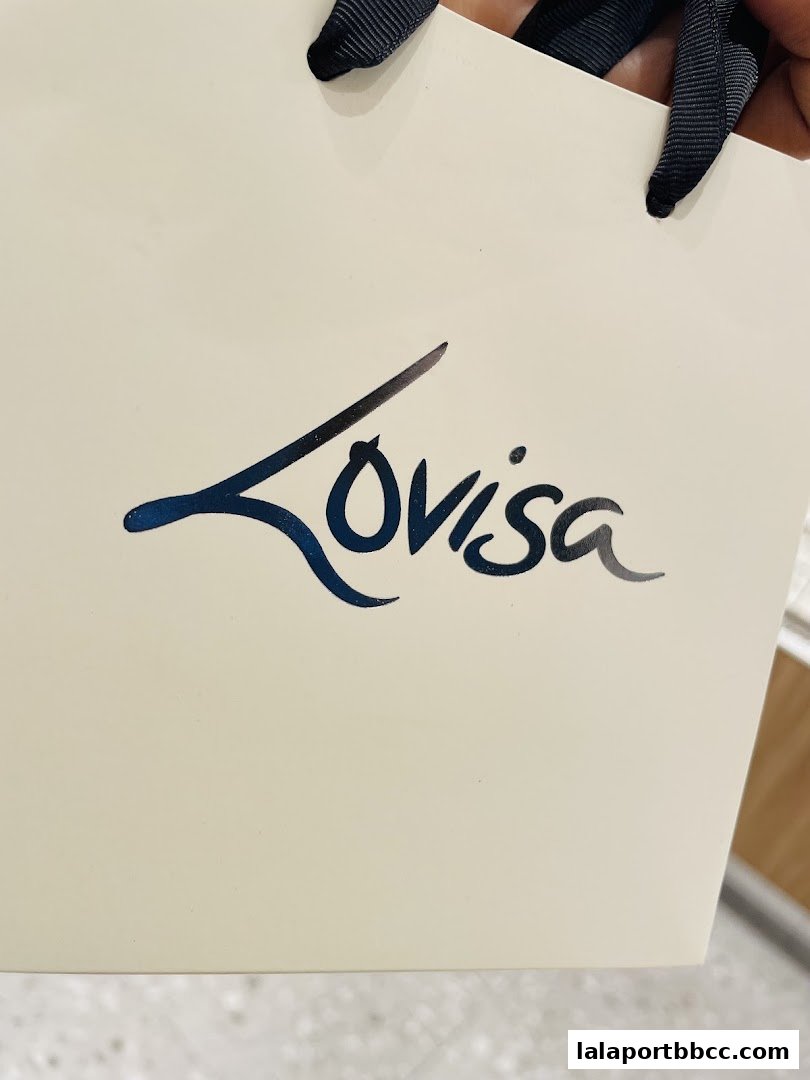A cream-colored shopping bag with the Lovisa logo and ribbon handles.