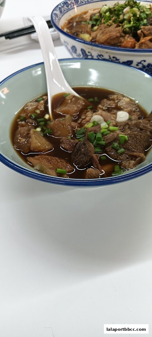 A close-up of a bowl of Hong Kong-style beef noodle soup with tender meat and broth.
