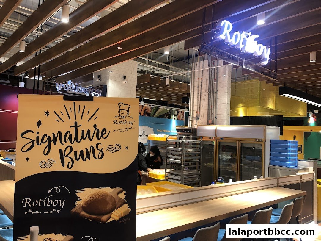 A food stall with a prominent sign advertising 'Signature Buns' and a view of the counter and kitchen area.