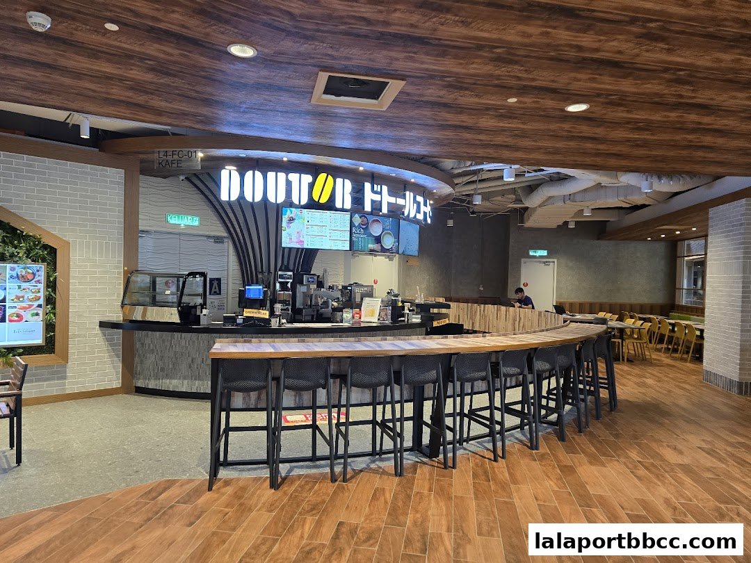 Interior view of a DOUTOR COFFEE shop with a counter, seating, and menu displays.