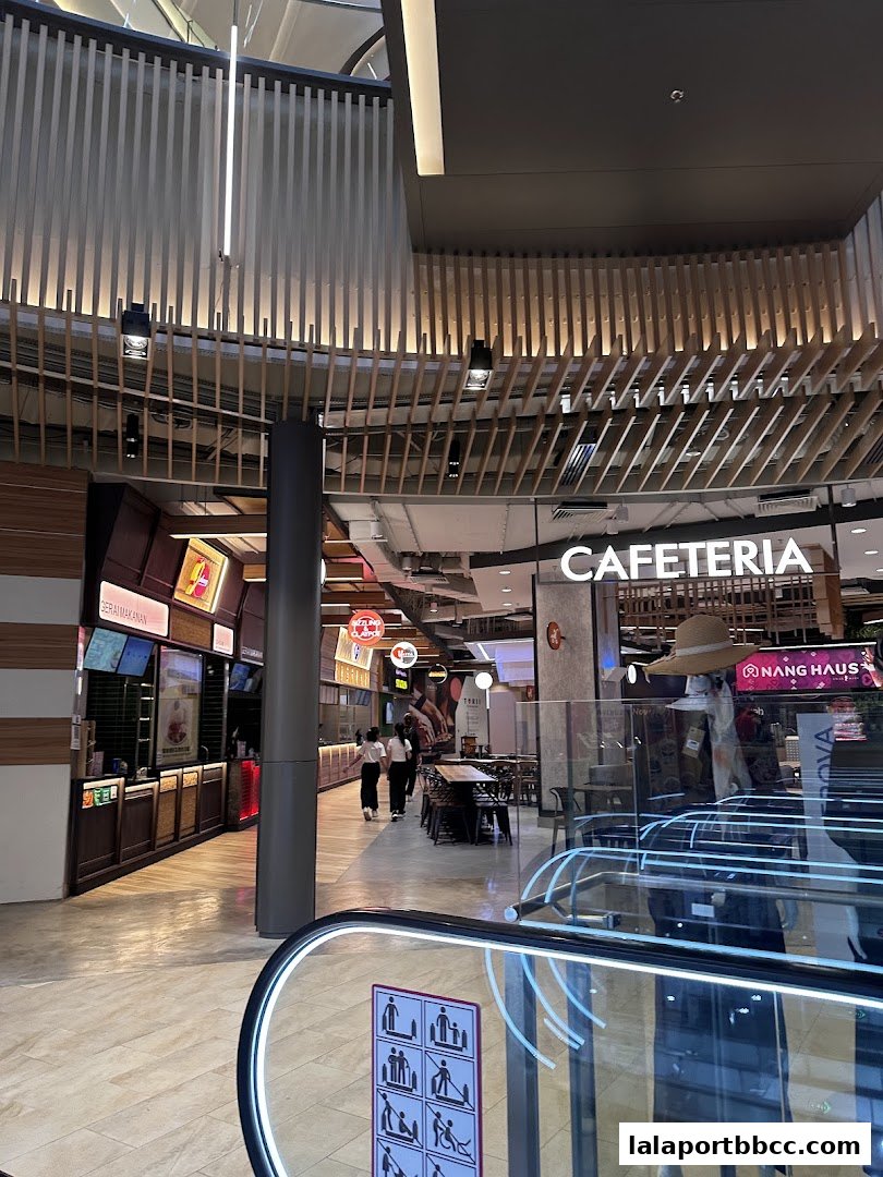 A view of a modern cafeteria area with seating and food stalls.