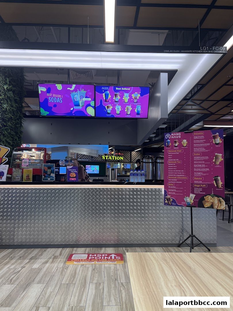 A beverage shop counter with digital displays and a menu stand.