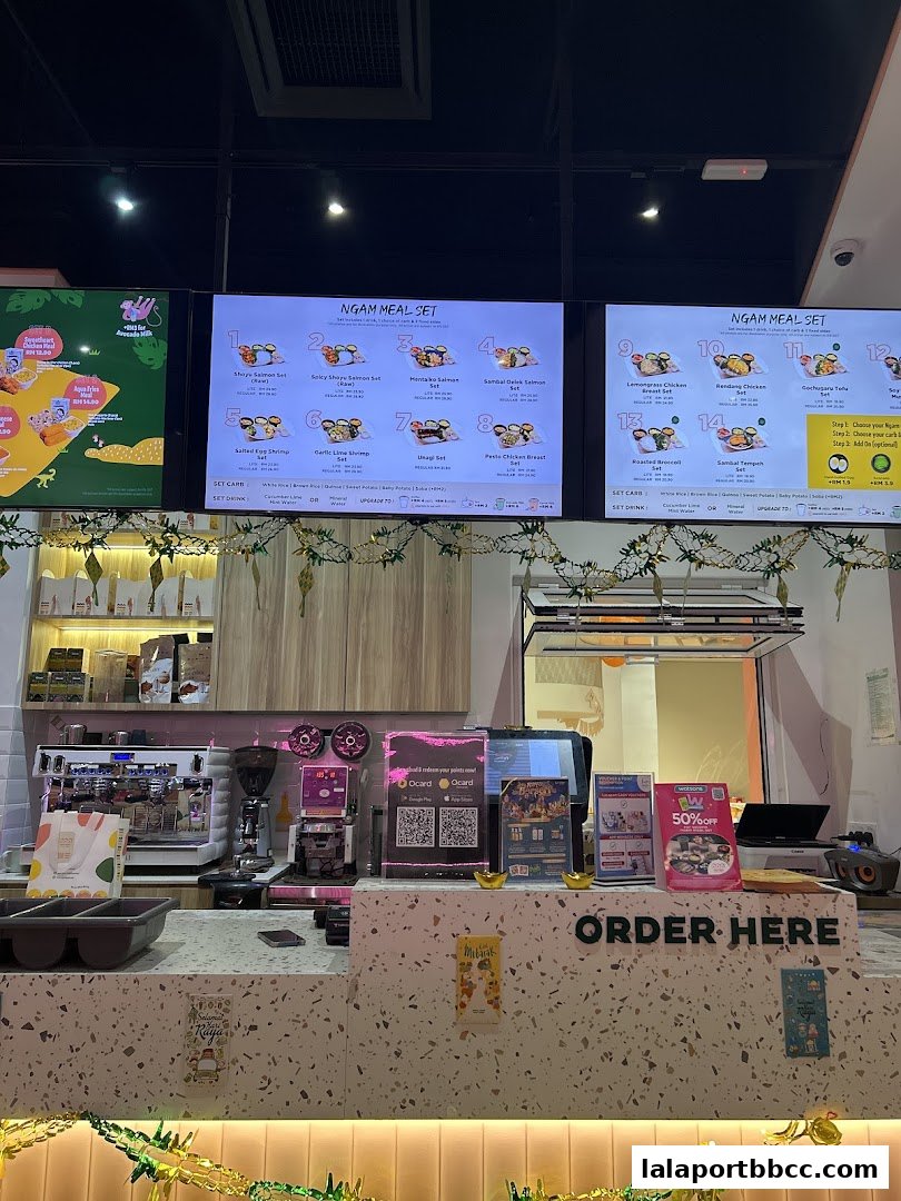 A digital menu board displaying various meal sets with food items and prices.