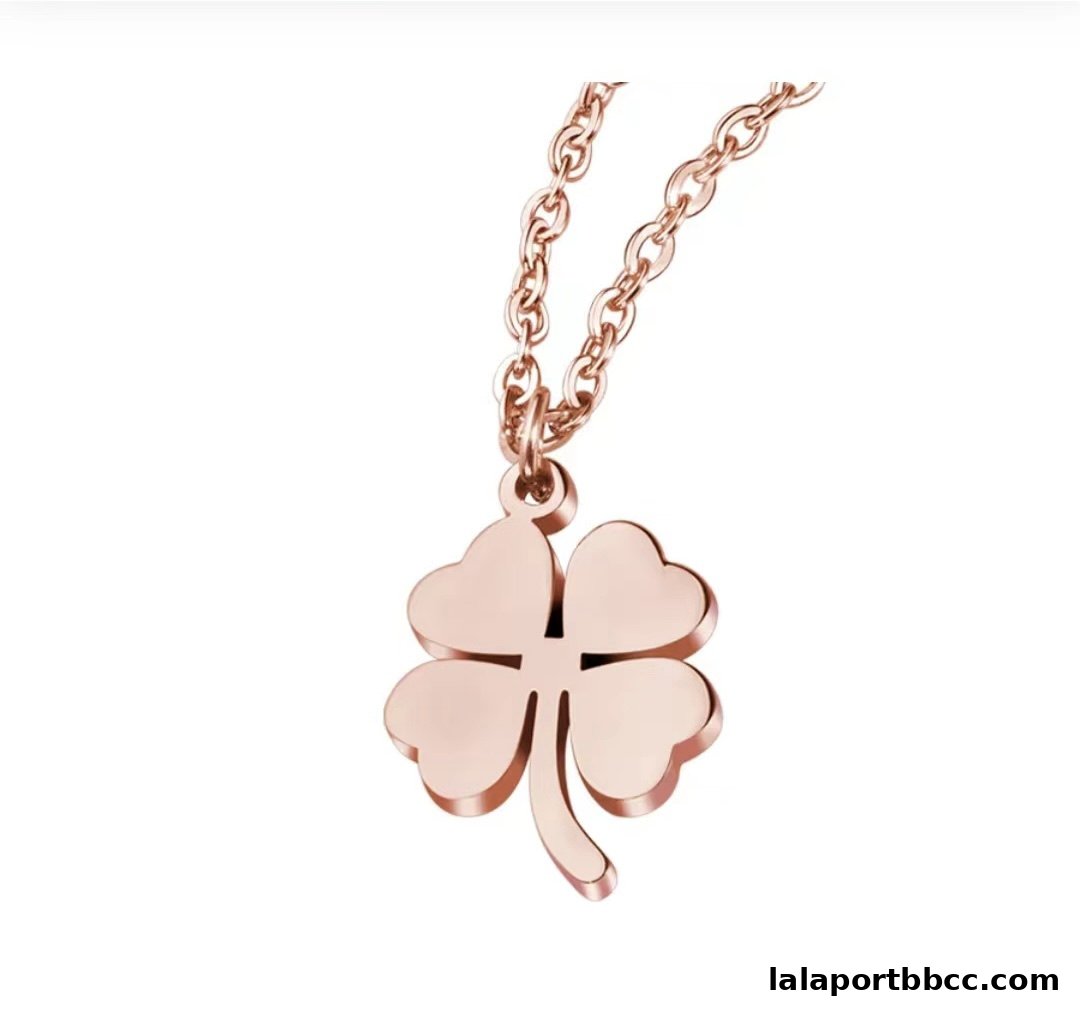 A rose gold necklace with a four-leaf clover pendant on a white background.