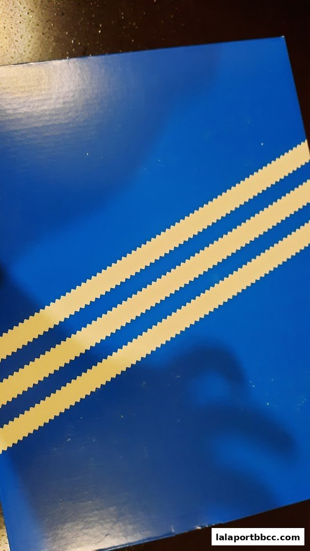 A blue box with the iconic Adidas three stripes in yellow.