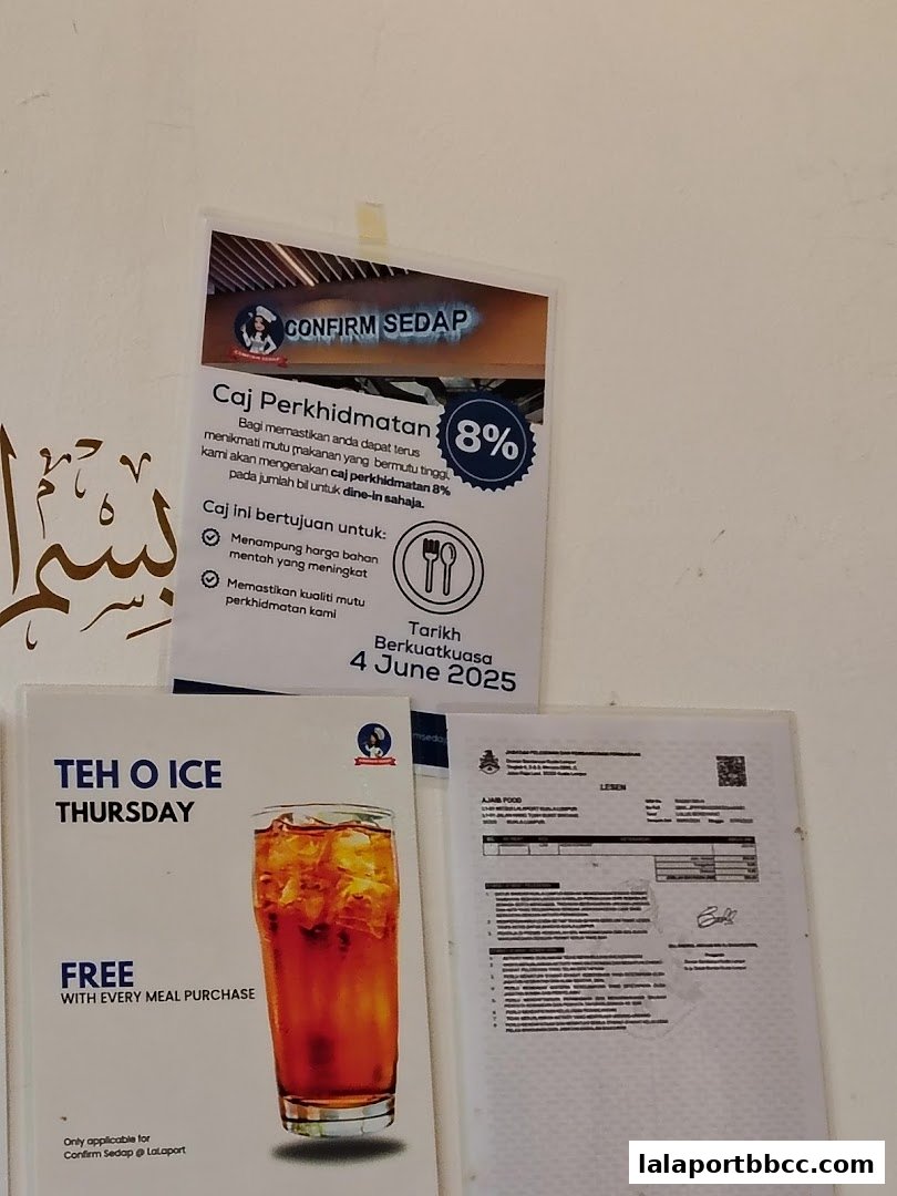 A sign about service tax and a promotion for free Teh O Ice on Thursdays.