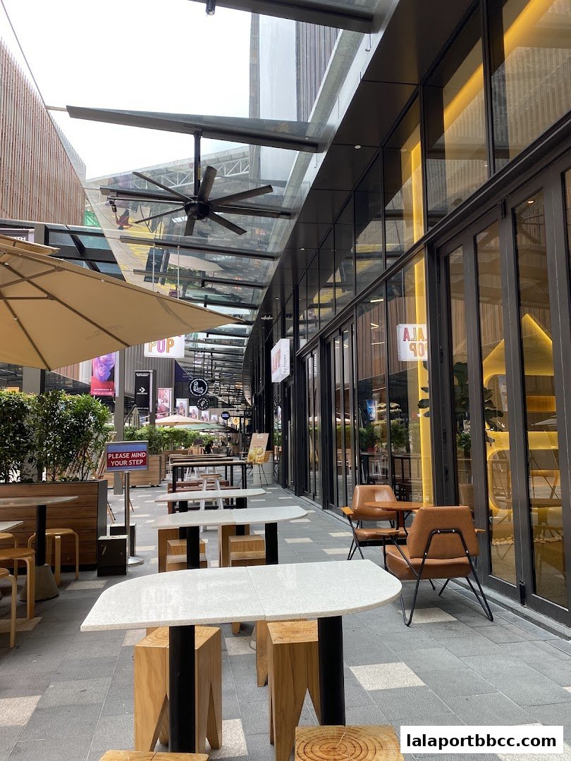 Outdoor seating area with tables and chairs at Gourmet Street, Lalaport BBCC.
