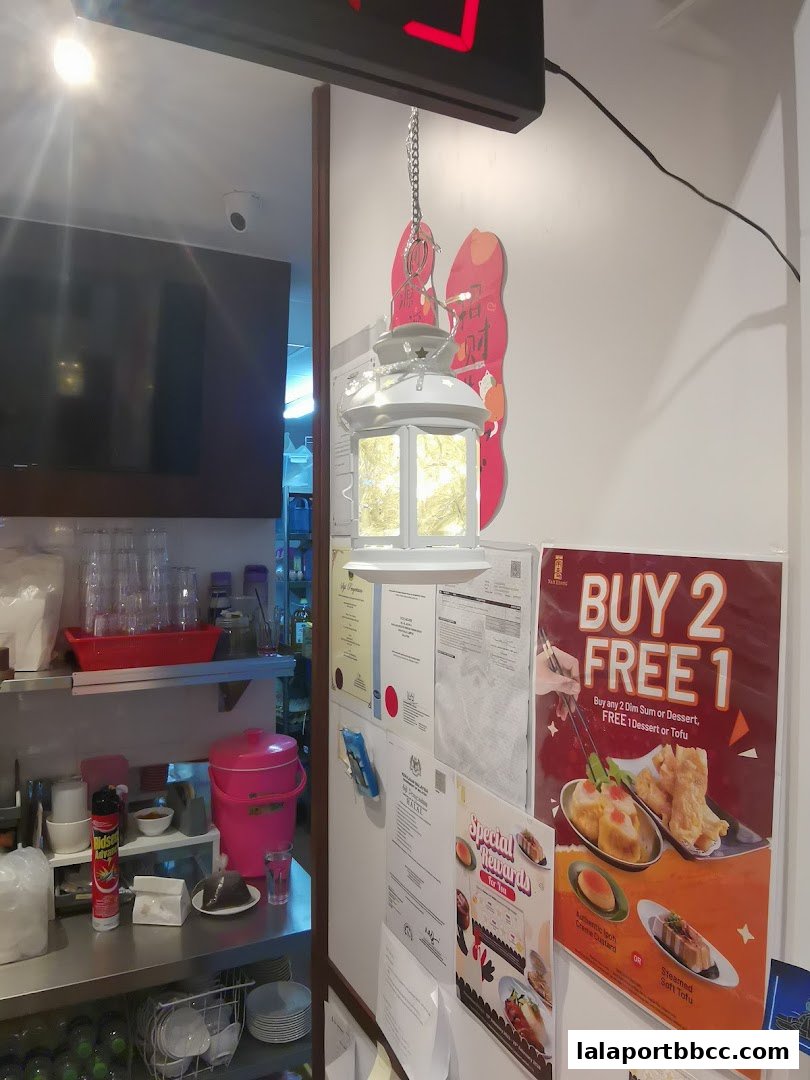 Interior view of Nam Heong Chicken Rice with promotional posters and kitchen supplies.
