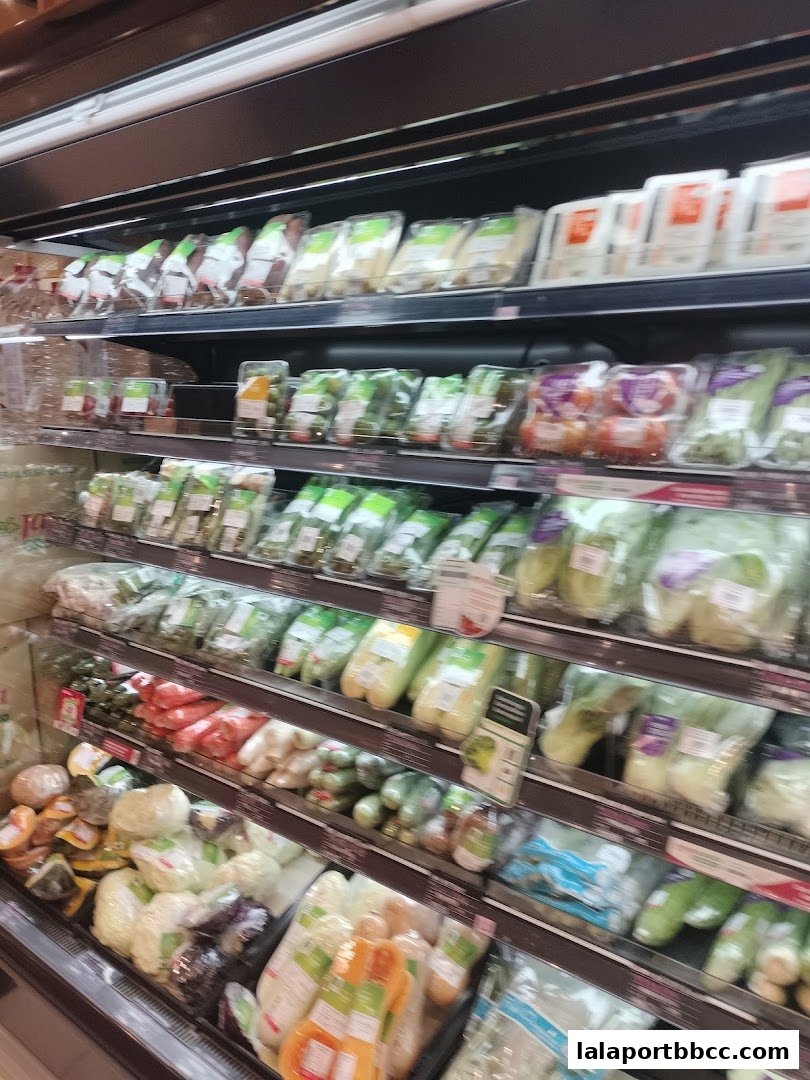 Shelves stocked with a variety of fresh, pre-packaged vegetables and produce.
