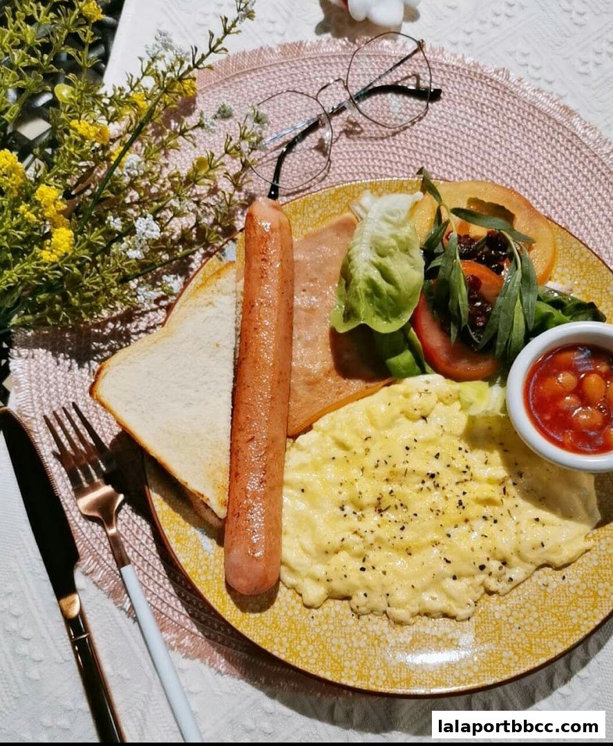 A delicious breakfast spread with scrambled eggs, sausage, toast, beans, and salad.