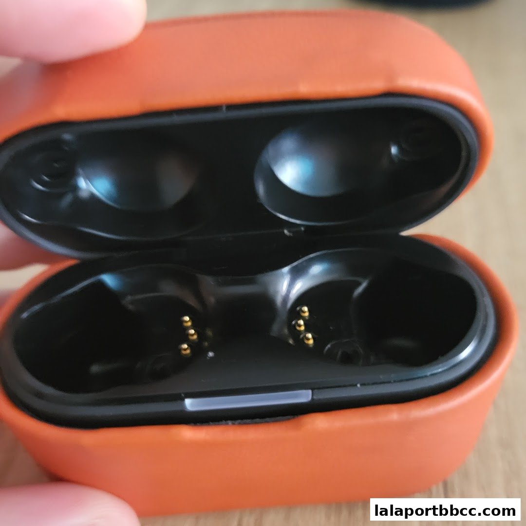 Close-up of an open orange charging case for wireless earbuds.