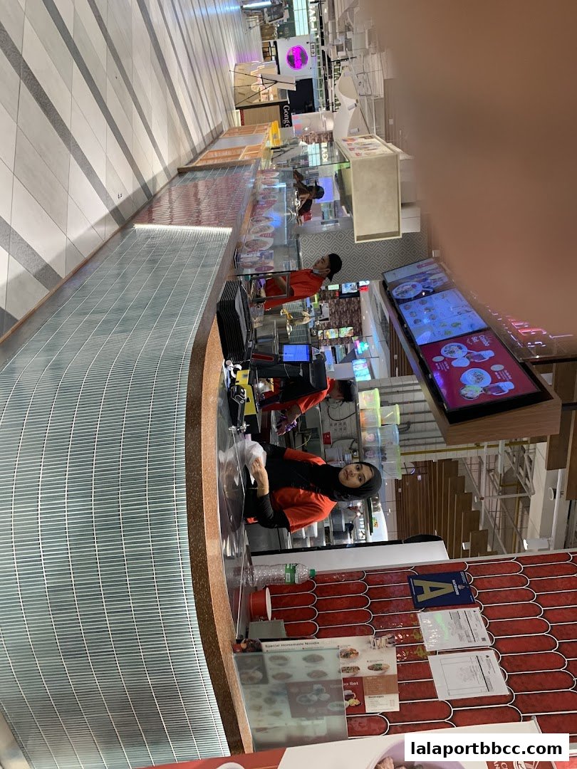 Staff members working at a food stall counter in a shopping mall.