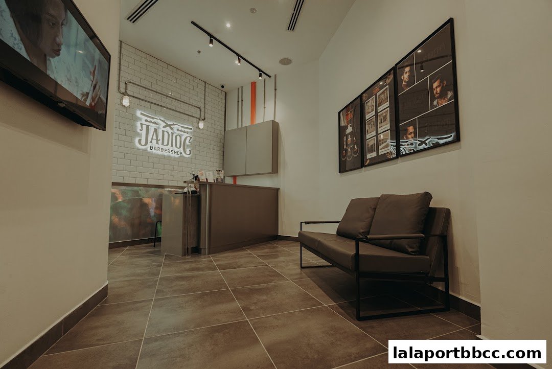 Interior of Jadioc Barbershop with a reception desk, seating area, and artwork.