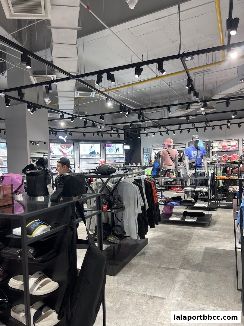 Interior view of a PUMA store showcasing apparel, footwear, and accessories on display racks.
