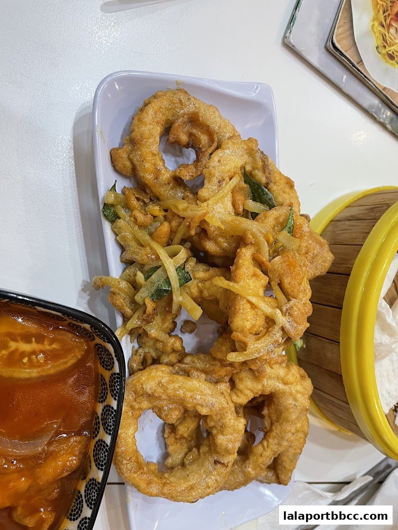 Crispy fried calamari rings served with a side of sweet and sour sauce.