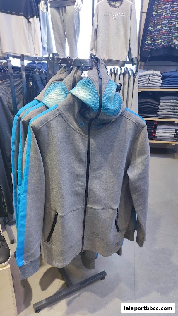 A display of grey hooded jackets with blue accents hanging on a rack.