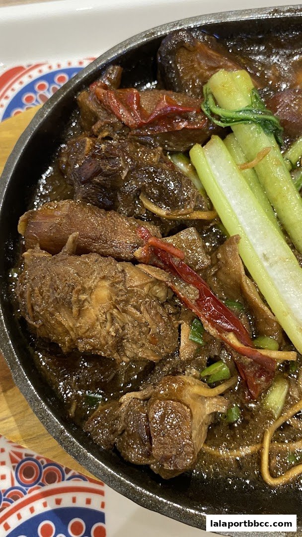 A sizzling hot plate of braised beef with vegetables and dried chilies.
