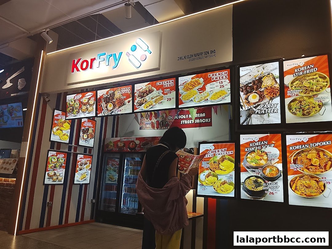 A KorFry shop front displaying various Korean street food menu items and a customer browsing.