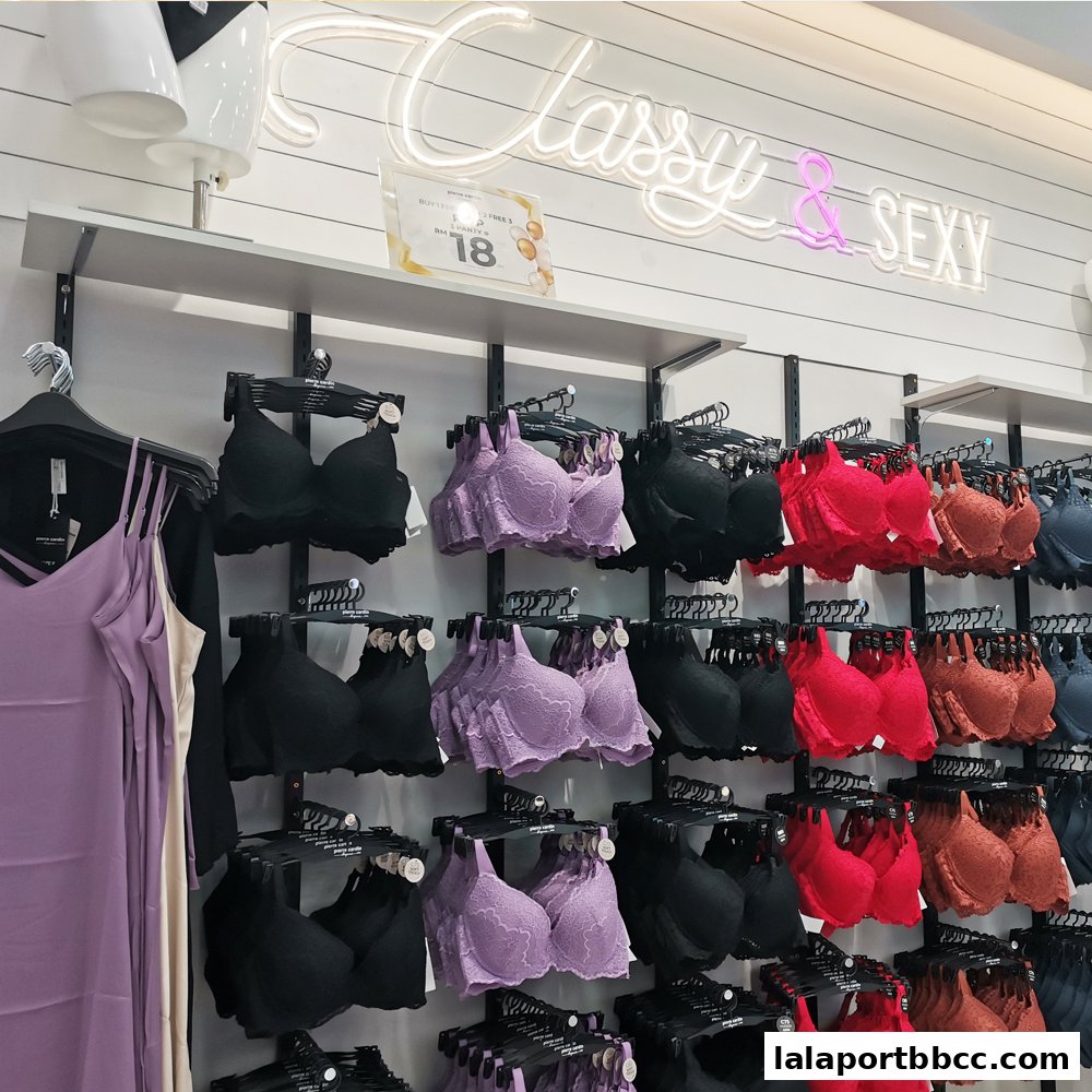 A display of colorful bras and lingerie in a retail store, with neon signs overhead.