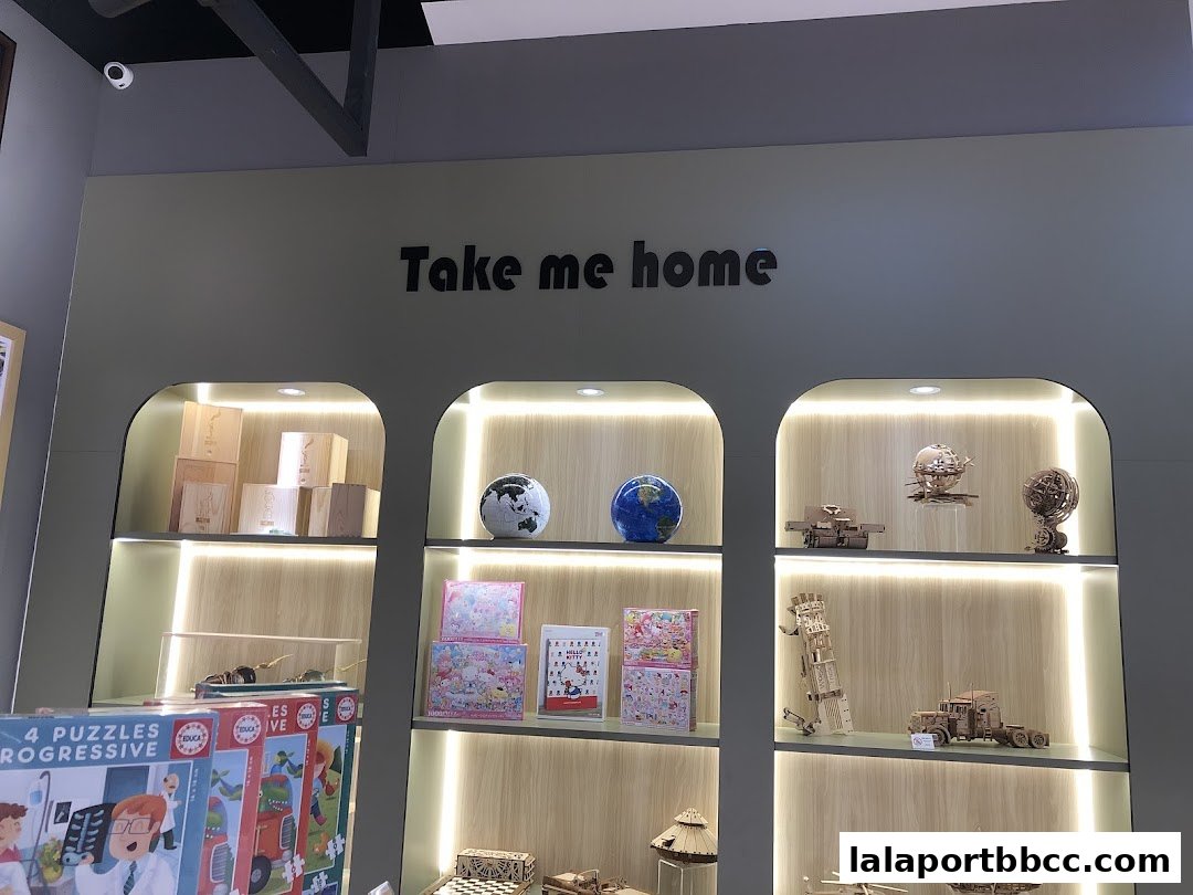 Shelves display various puzzles, wooden models, and decorative globes in a brightly lit shop.